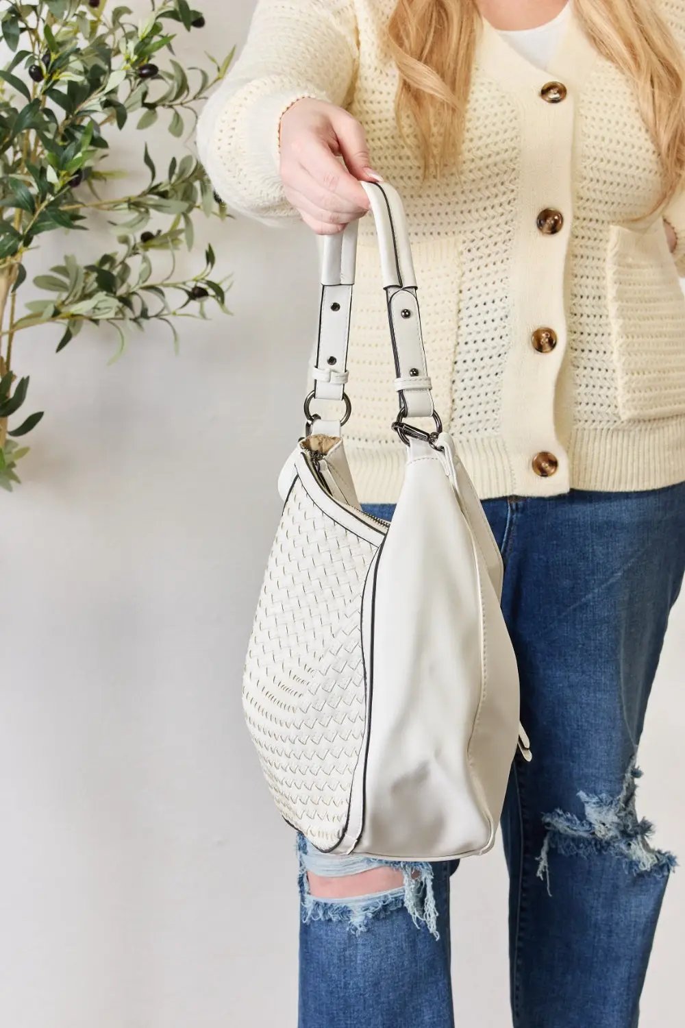 a woman holding a white purse in her hand