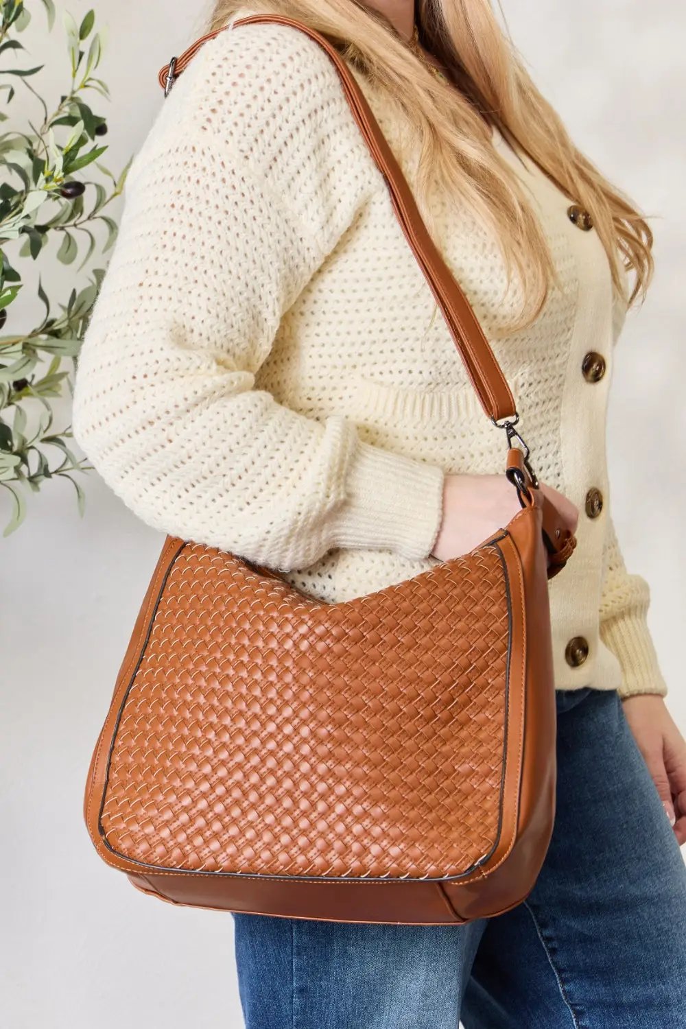 a woman standing in a room holding a purse